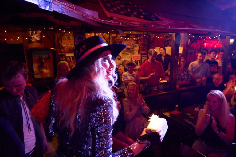 Frau mit Hut bei Auftritt im vollen Club.