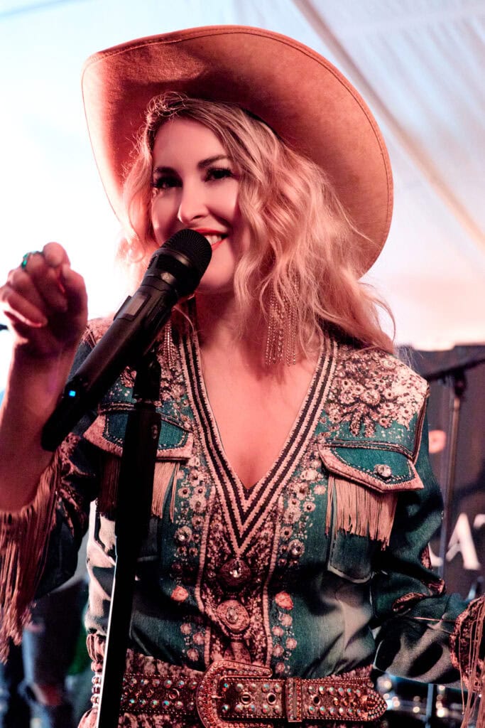 Sängerin mit Cowboyhut singt auf der Bühne