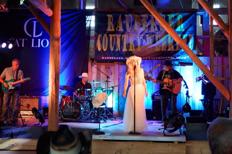 Country-Band spielt live auf Holzbühne mit Beleuchtung.