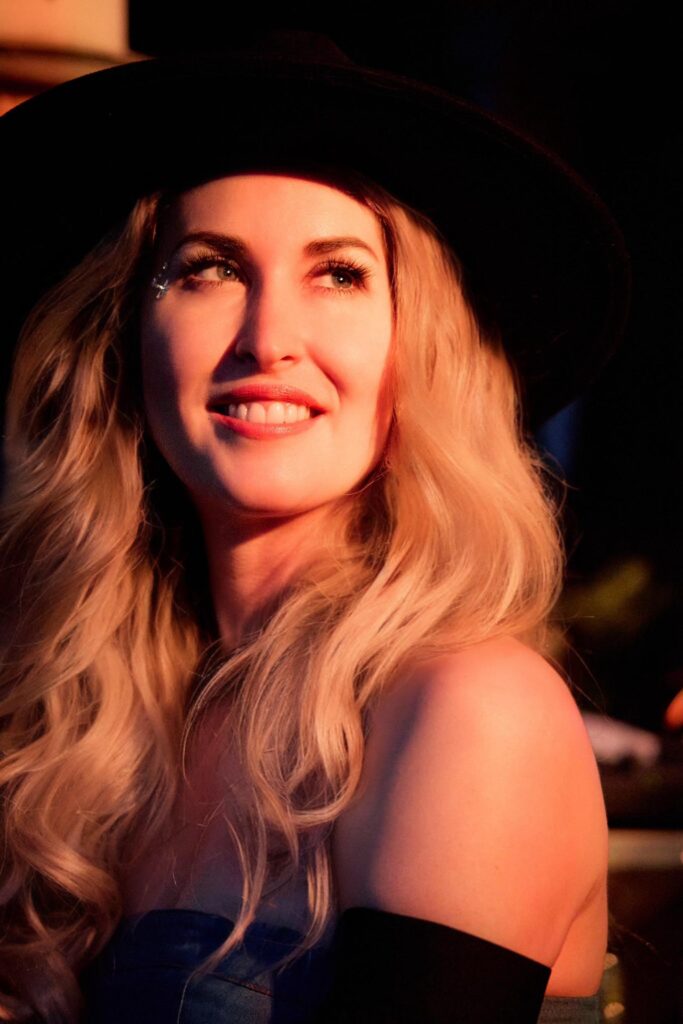 Frau, rotes Licht, schwarzer Hut, lächelnd